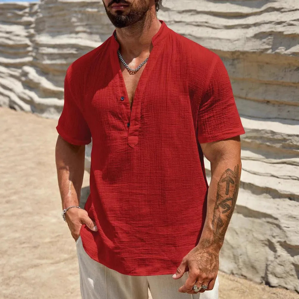 Man wearing a solid colour short-sleeve shirt with a stand collar in a casual setting.