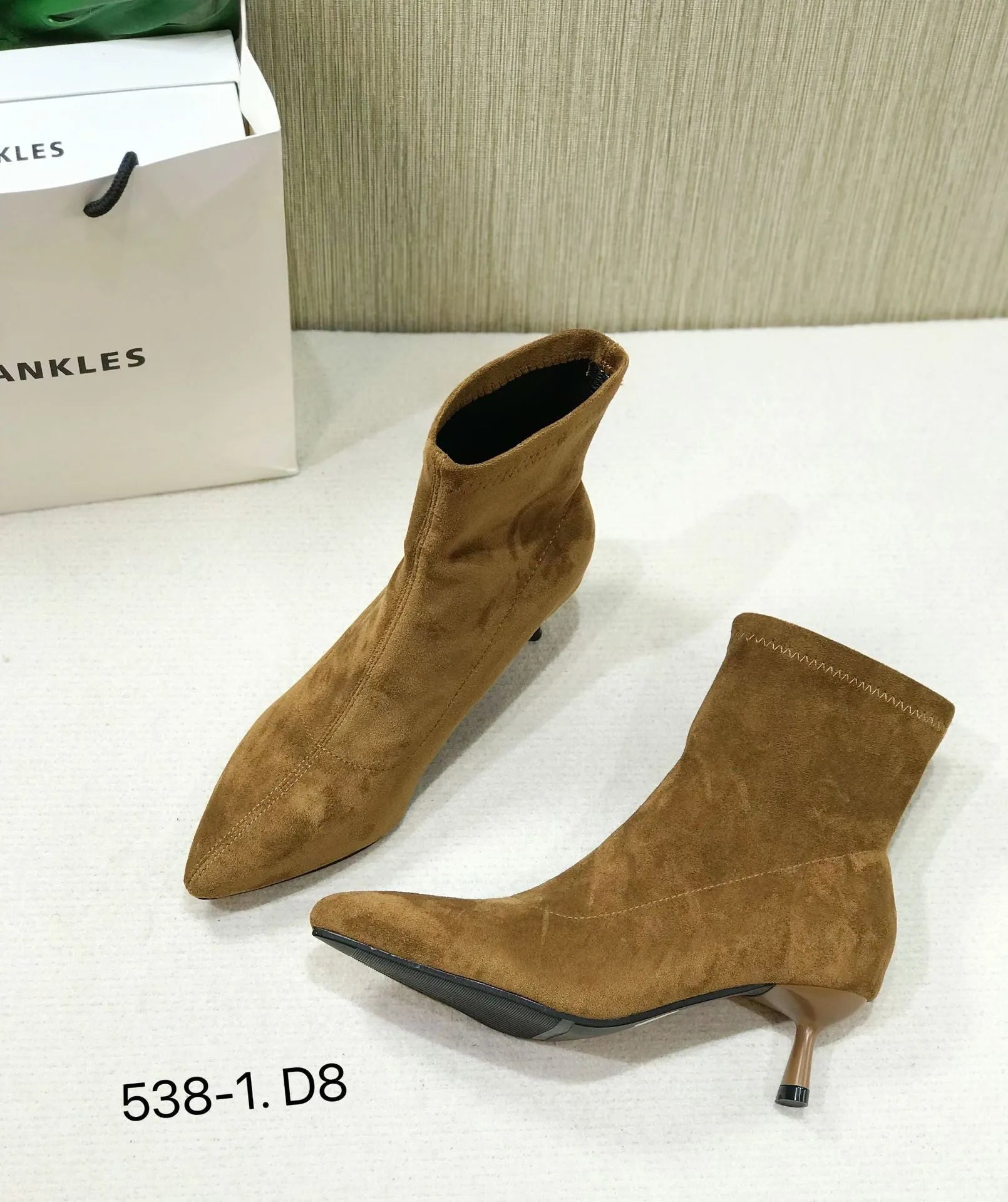Black pointed toe women's ankle boots with a stiletto heel on a neutral background.