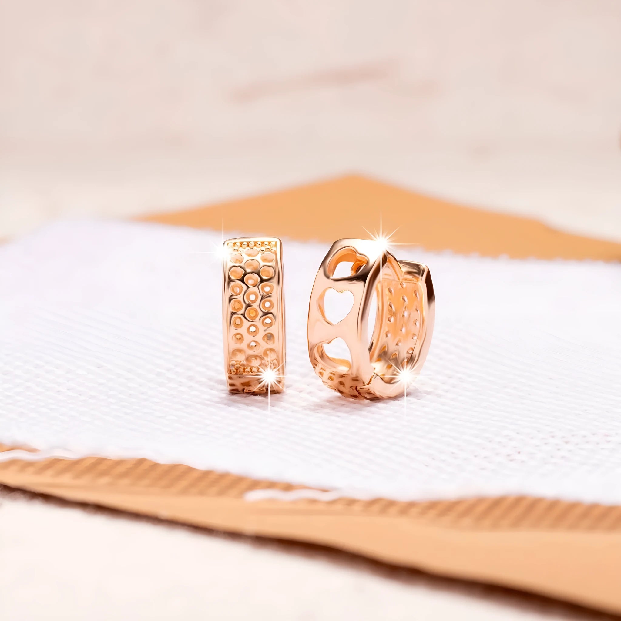 Rose gold electroplated earrings with three hollow heart shapes in circular arrangement