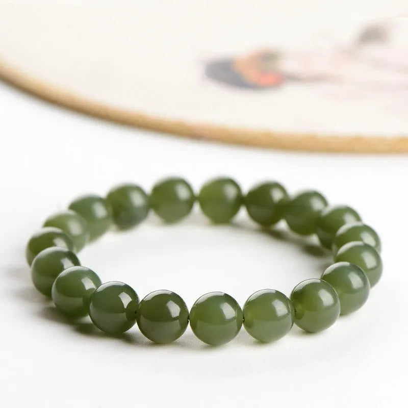 Hetian jade ball bracelet with polished beads in clear water colour on a string.