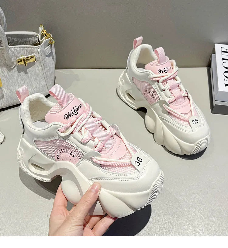 Women's pink casual sneakers with cross strap design and thick sole showing side profile