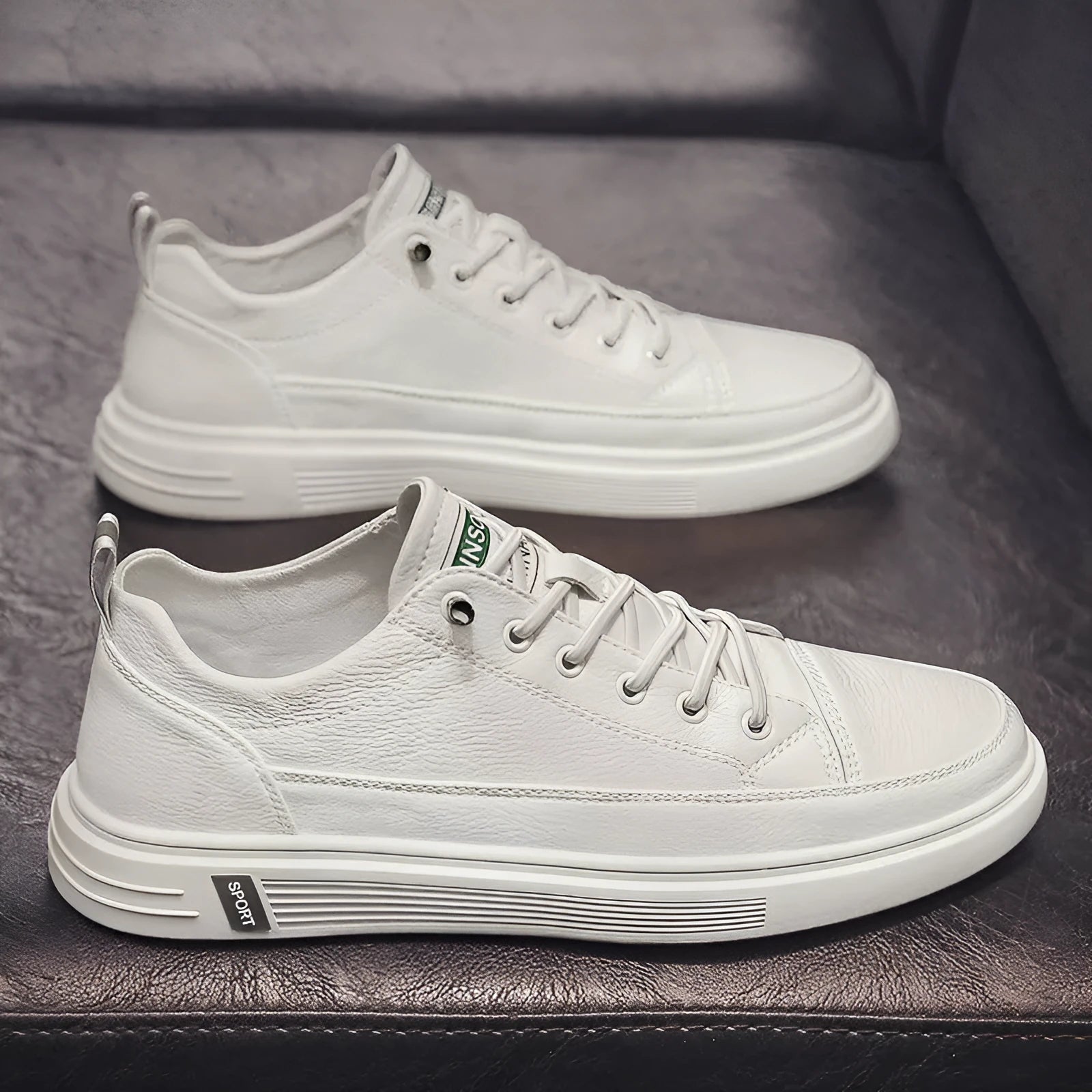 Men's white casual shoes with round toe and flat low heel on a plain background