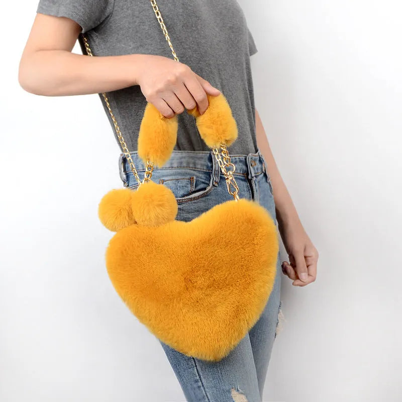 A soft plush heart-shaped women's handbag with a zipper and a detachable shoulder strap in a choice of 14 colours.