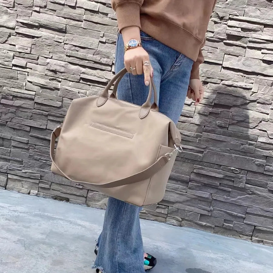 Black waterproof nylon shoulder bag with leather trim showing front view and interior