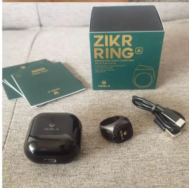 Zikr1 Lite Tasbih smart ring in silver on a charging case with USB cable.