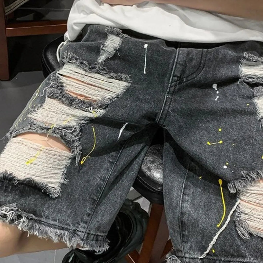Men's loose fit water washed denim shorts with hole details in light blue, showing fifth pants length.