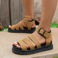 Black thick-soled beach sandals with an adjustable buckle strap and round toe.