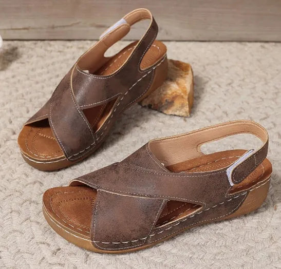 Women's brown platform Roman sandals with Velcro strap and open toe on a rubber sole.