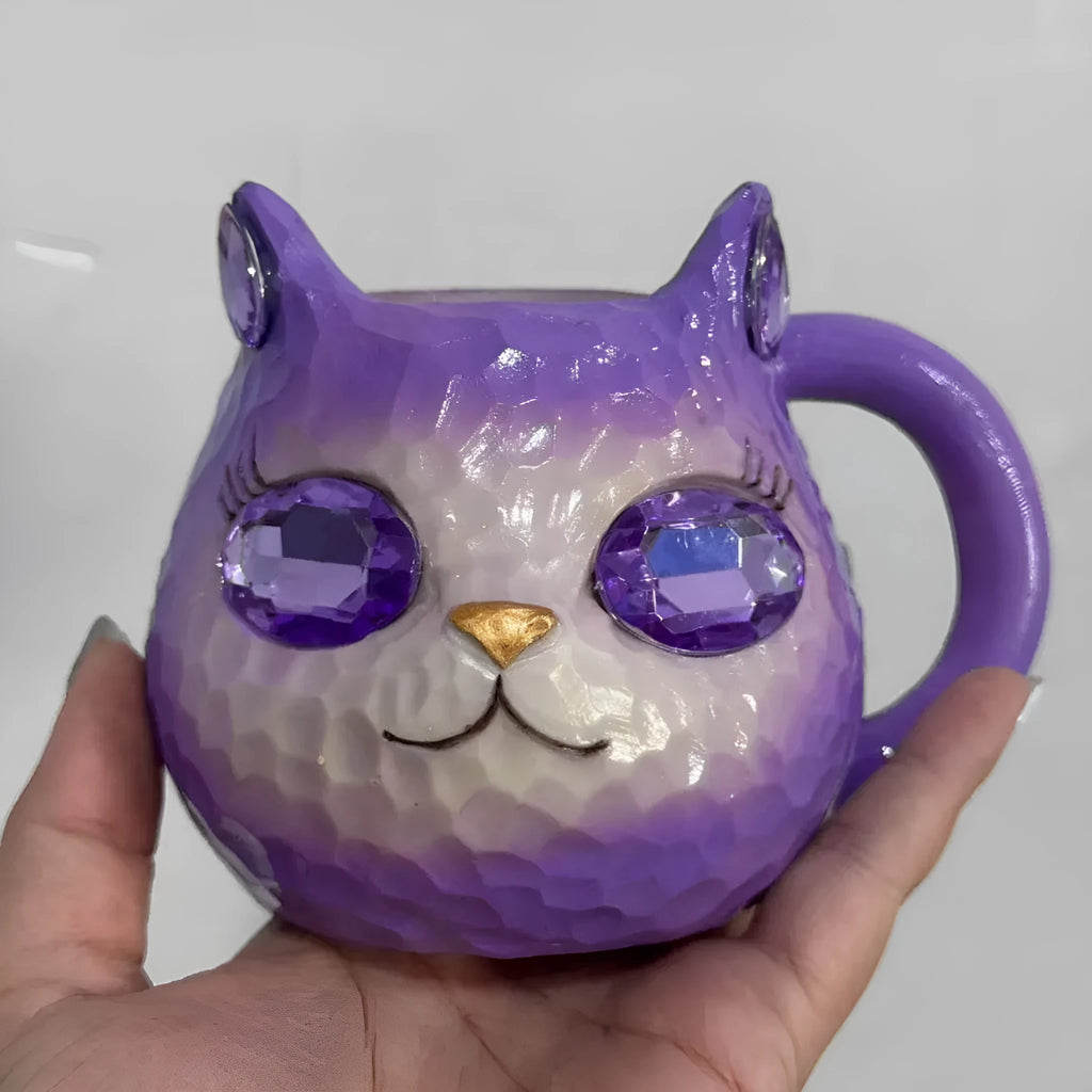 Coloured resin cat cup decoration in purple, green, blue, or pink on a shelf.