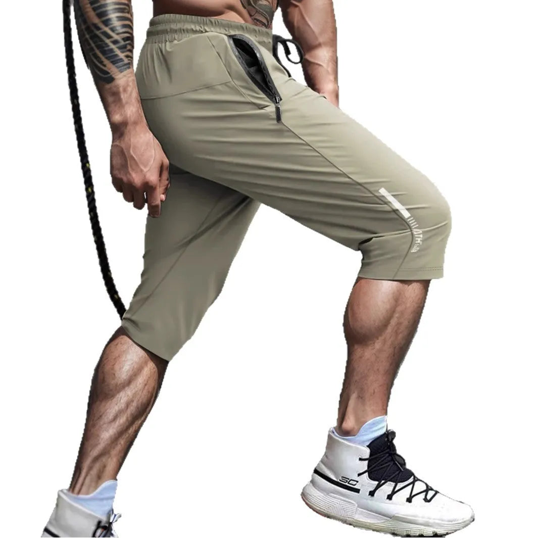 Man wearing black cropped straight-leg sports casual pants made from quick-drying nylon fabric.