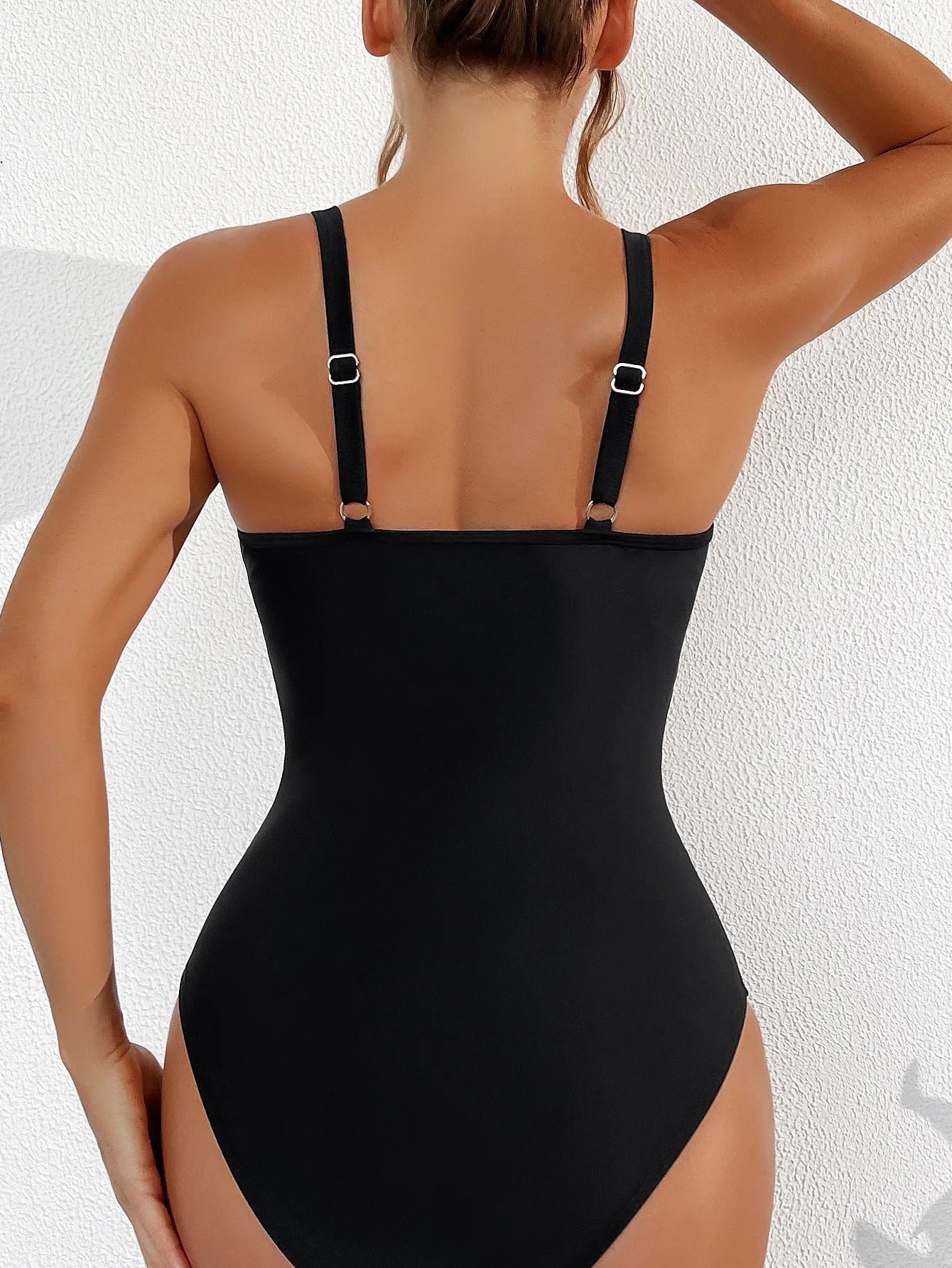 Black halter neck one-piece swimsuit with mesh detail, shown on model.