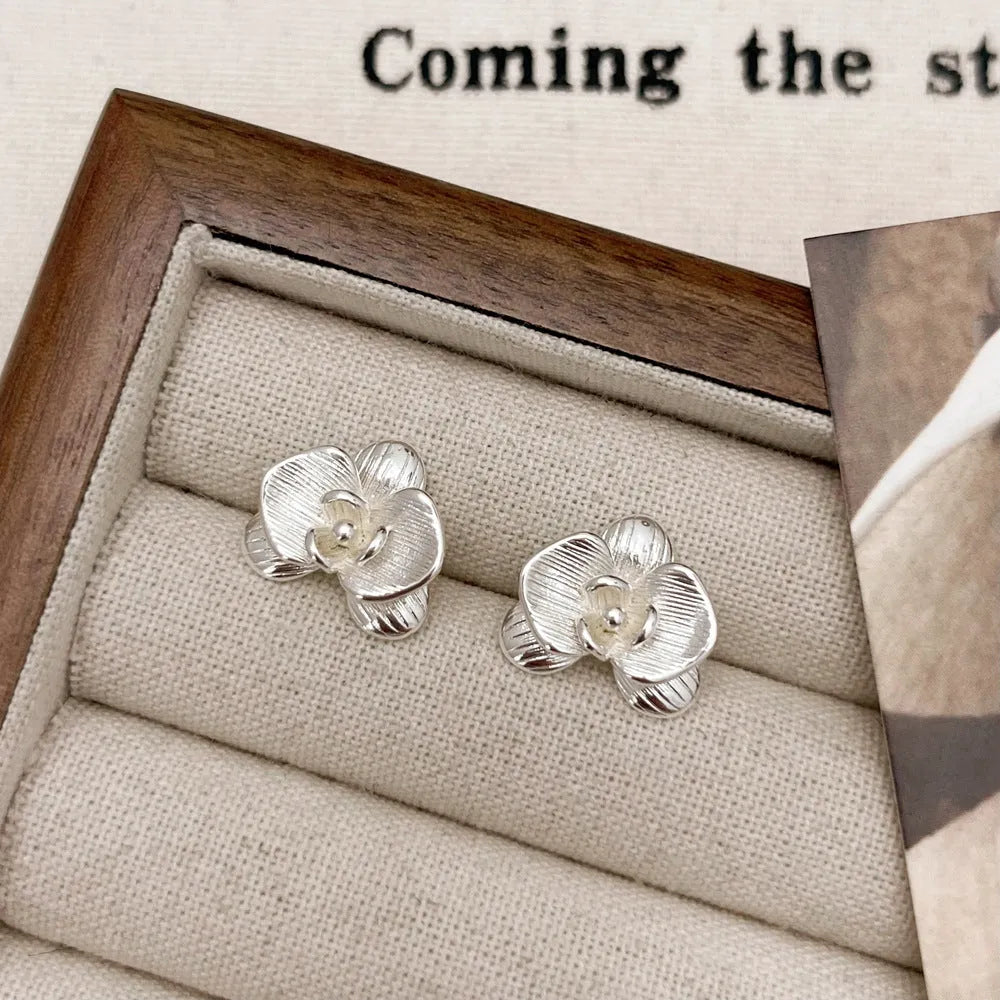 Retro flower earrings in gold or silver with detailed petal design on copper base