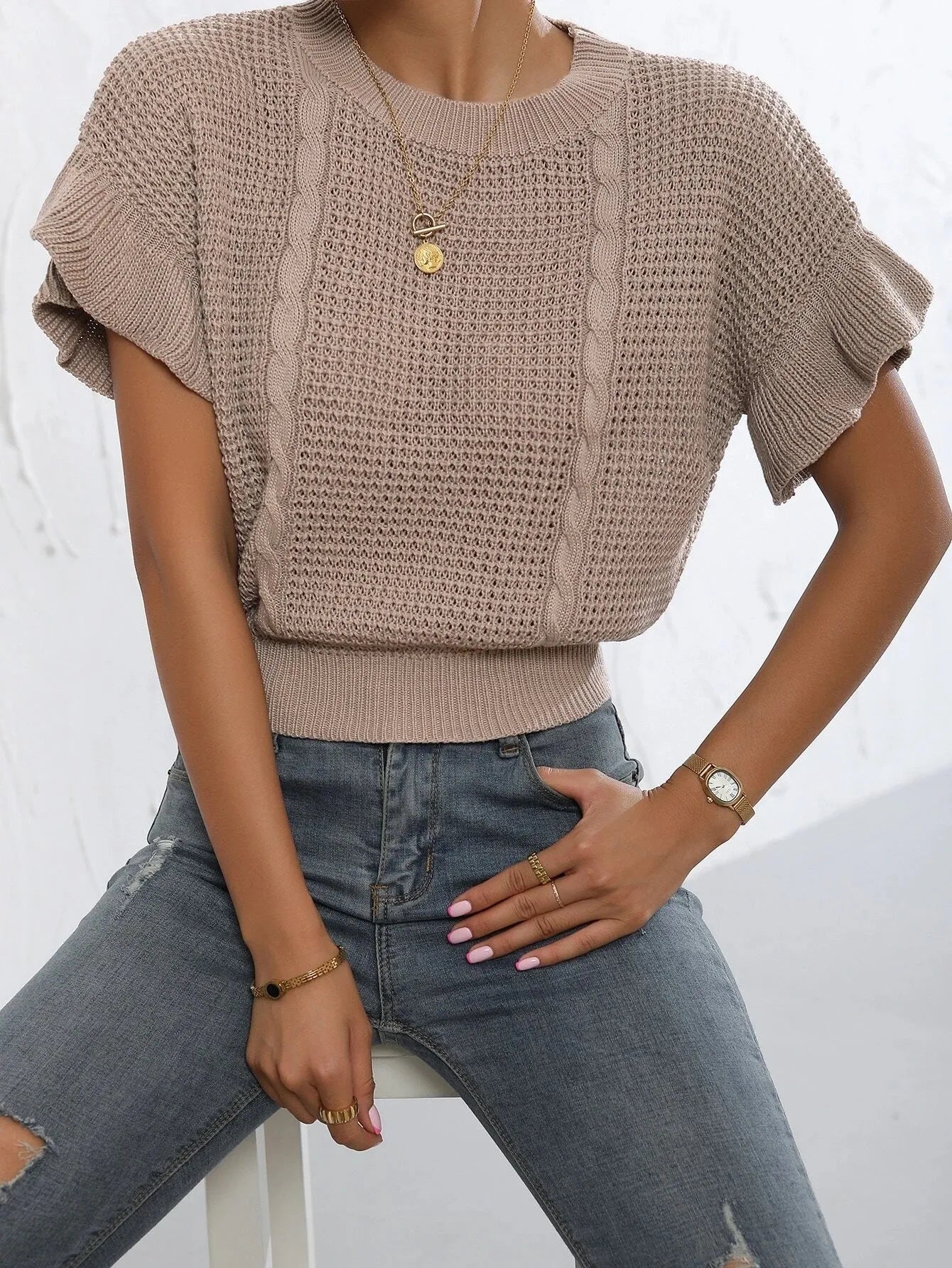 Twisted string detail and ruffled short sleeves on a loose-fit round neck knitted pullover sweater.