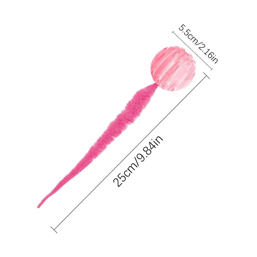 Green interactive cat toy featuring a bouncy ball with a long plush tail on a wooden floor.