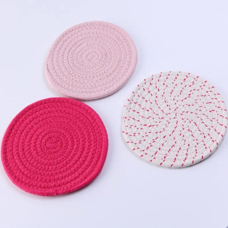Set of three round grey cotton cord coasters on a wooden table, each 18cm in diameter.