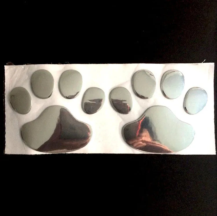 Pair of hand-shaped brush dog footprint PVC car stickers in red, shown against a car bumper.