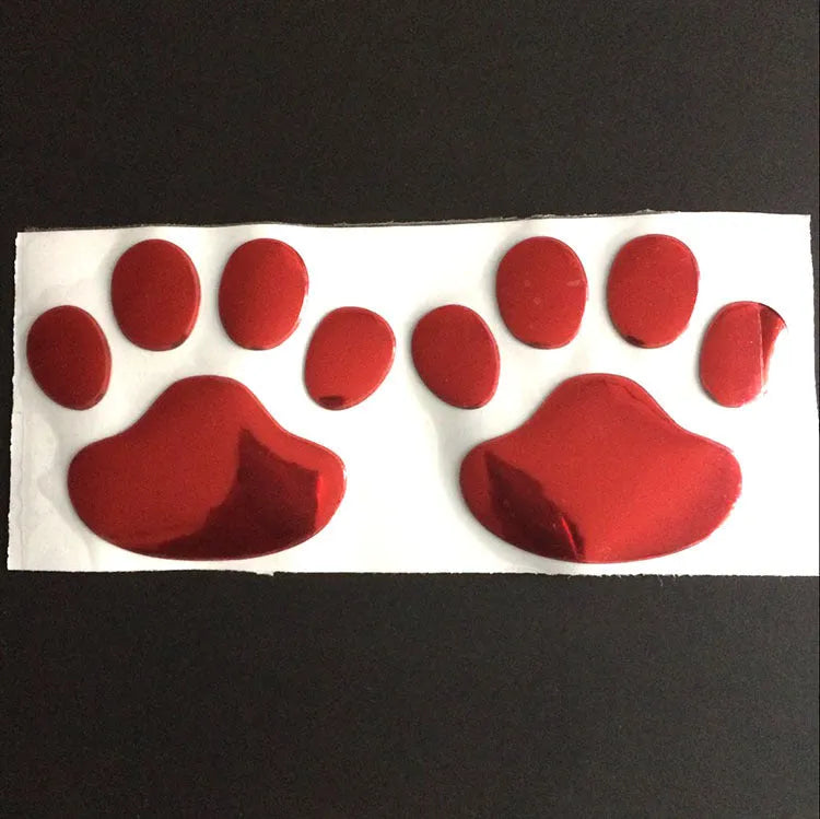 Pair of hand-shaped brush dog footprint PVC car stickers in red, shown against a car bumper.