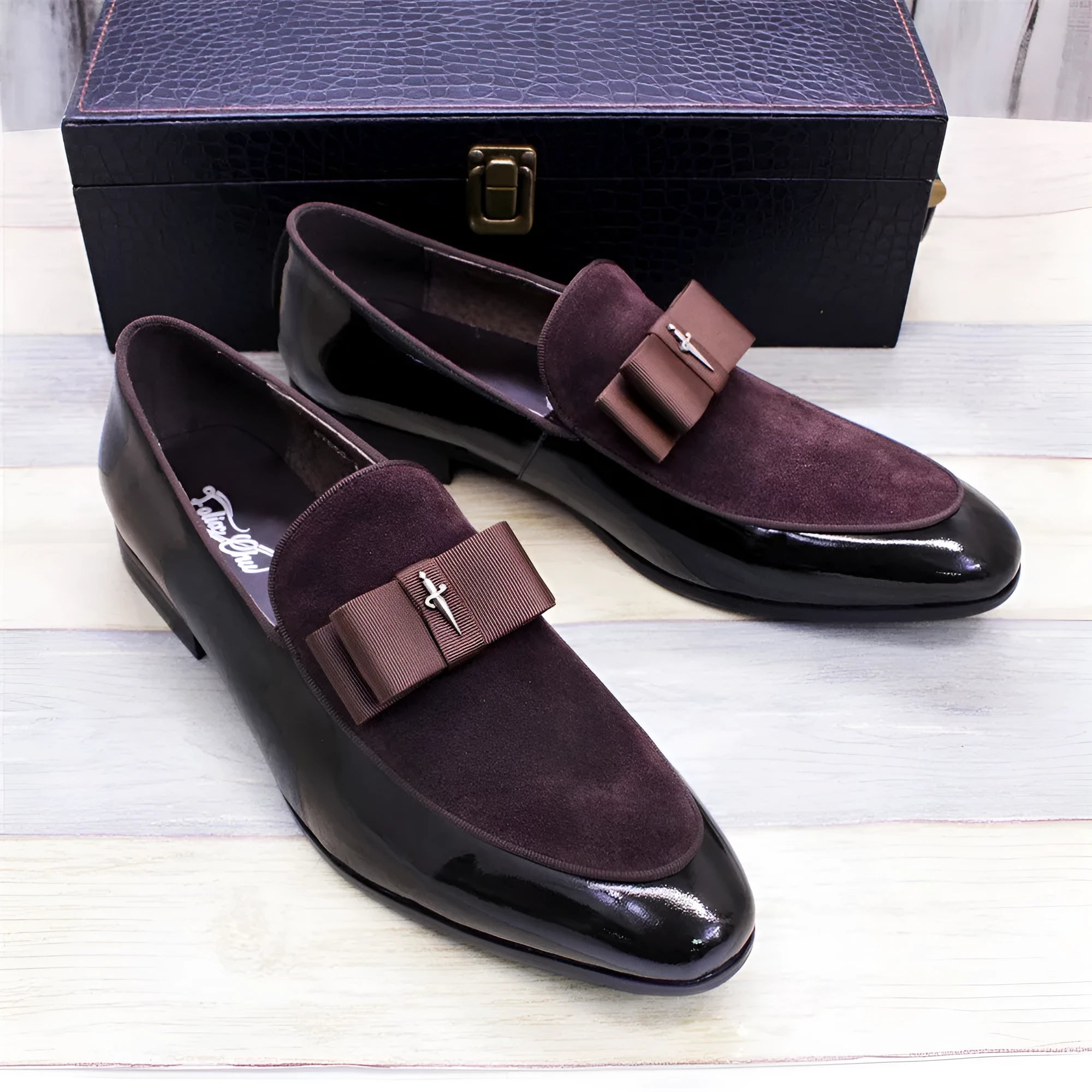 Men's black patent leather low-top shoes with a gold tassel detail and rubber sole.