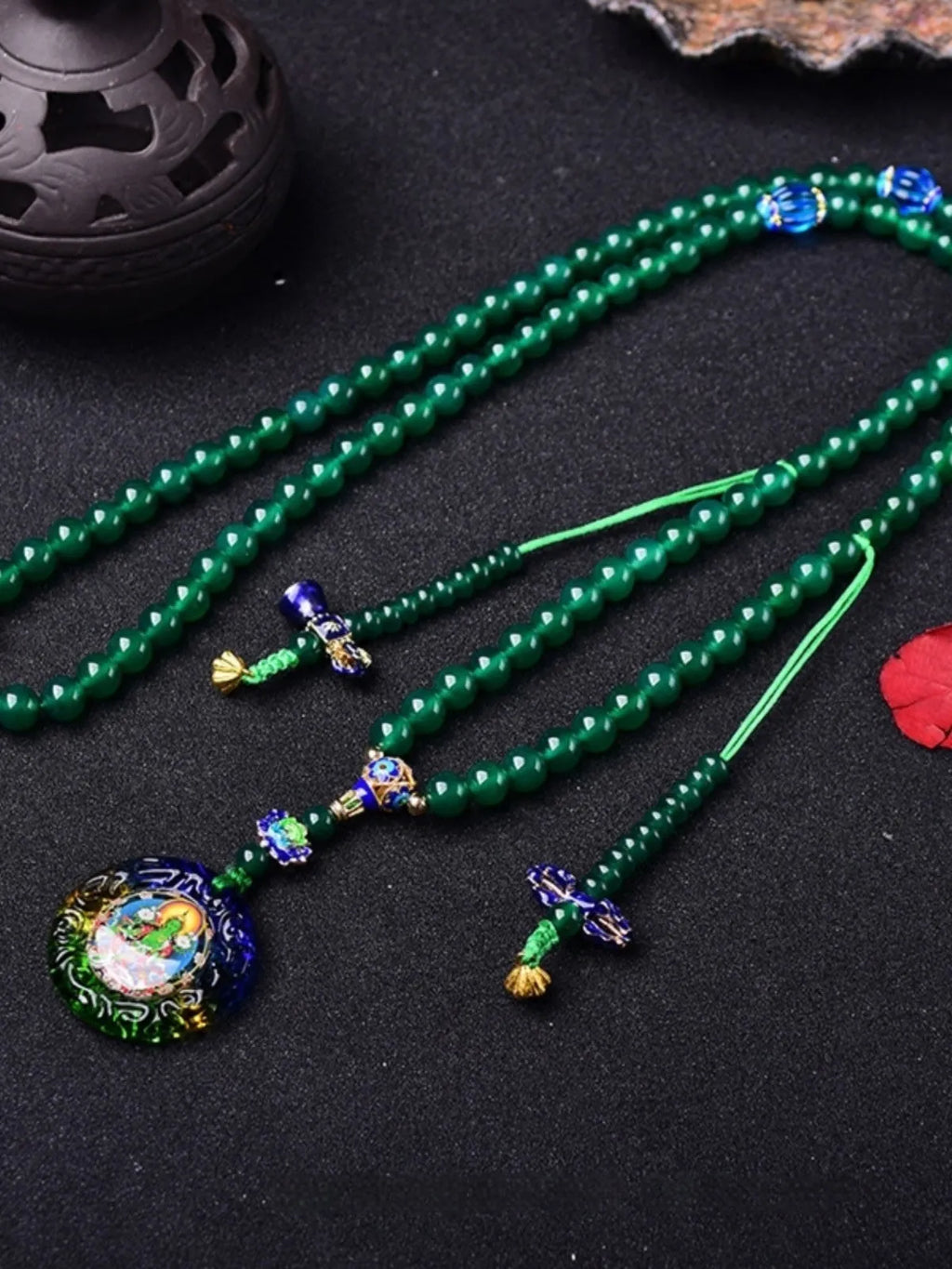 Natural green agate 108-bead bracelet with pendant in Thangka style on a wrist.