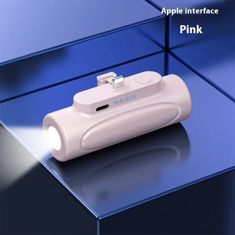 Black and pink creative power bank with integrated LED flashlight showing scale and port options.