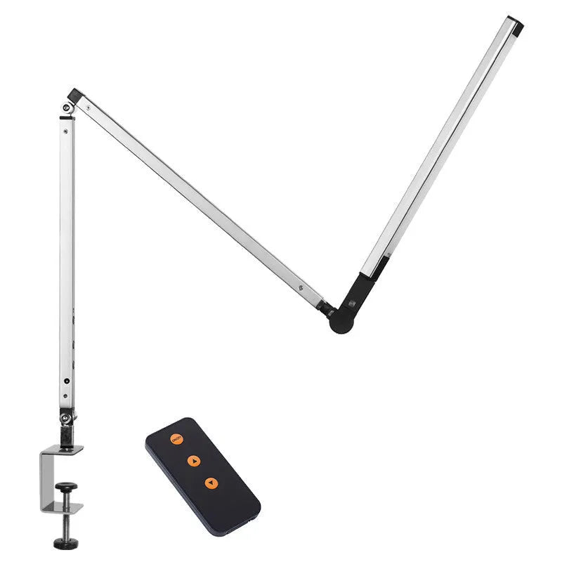 Folding aluminium desk lamp with a metal clip, shown in dazzling black, attached to a desk edge.
