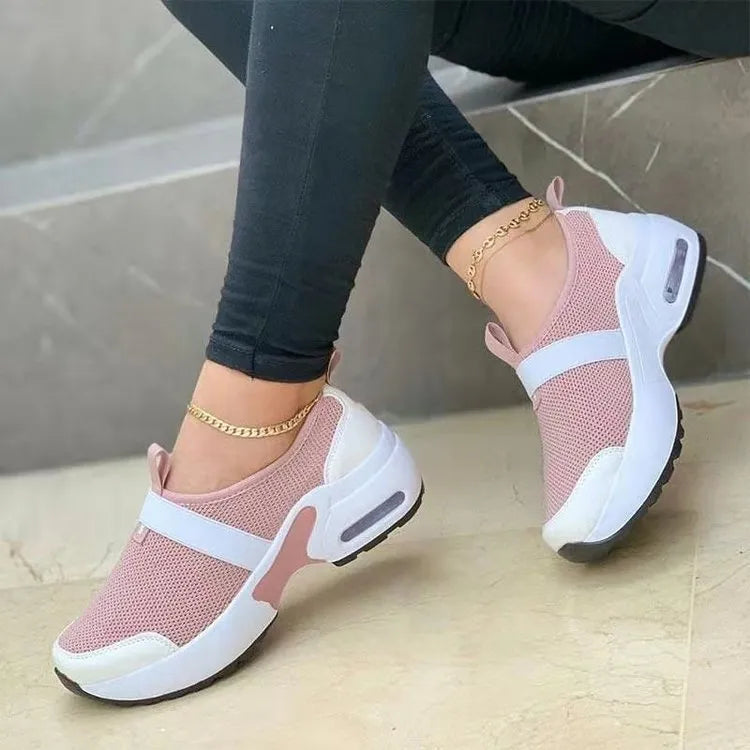 Women's white mesh flat sneakers with a rubber sole shown from the side.
