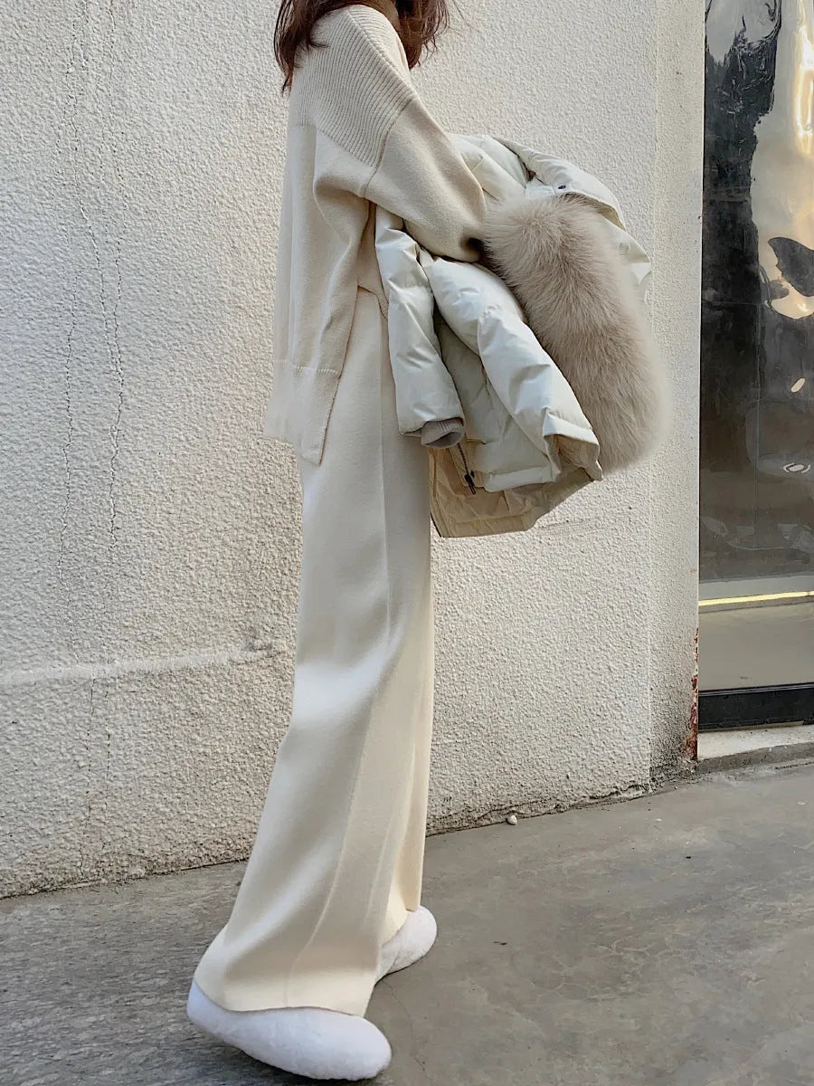 Women's cream white high waist wide-leg knitted trousers with a long mopping hem and elastic waistband.