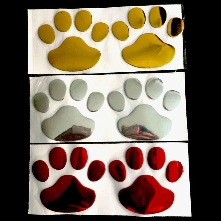 Pair of hand-shaped brush dog footprint PVC car stickers in red, shown against a car bumper.