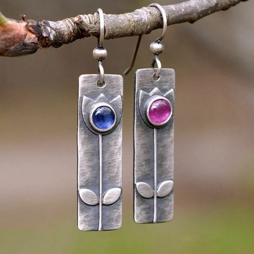 A pair of red sapphire earrings with an antique finish and geometric design.
