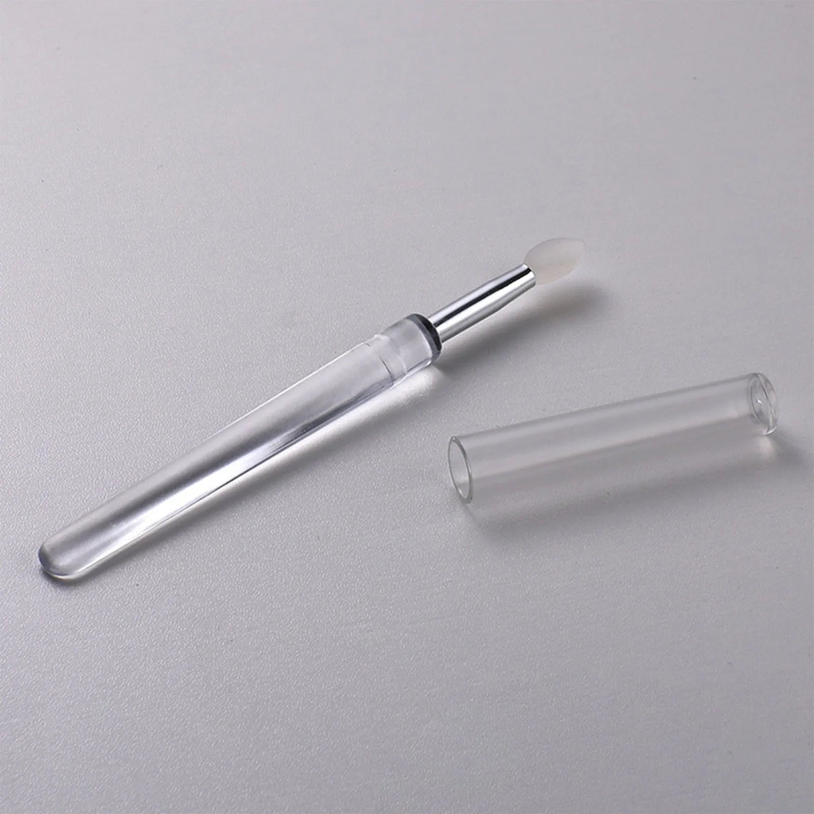 A reusable silicone lip brush with a handle and protective cap, shown in one of eight available colours.