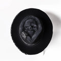 Handmade wool felt Halloween hat with a pointed conical crown in a skull design.