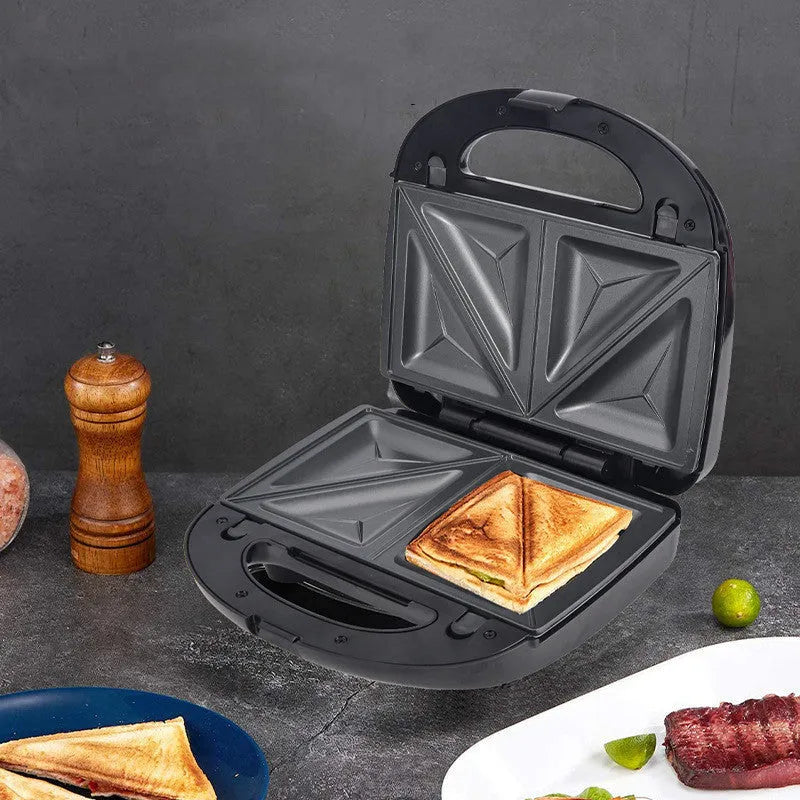 Black double-sided electric sandwich pan with brushed stainless steel lid and non-stick plates.