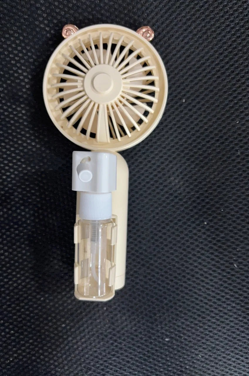 Plastic USB desk fan with a flexible nozzle in apricot colour on a wooden desk.