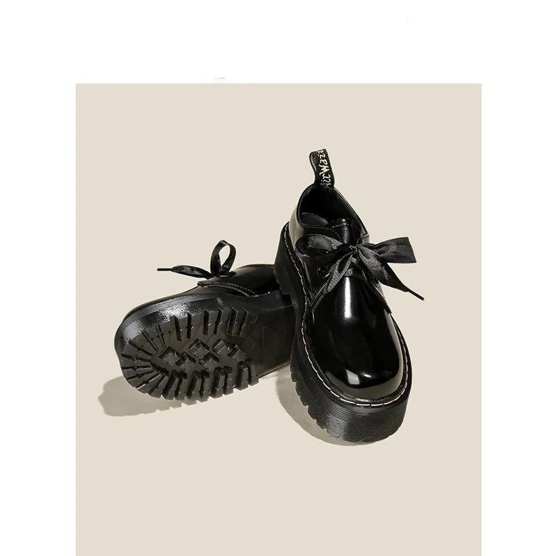 Women's black leather shoes with thick soles, ribbon cross-straps, and lace closure