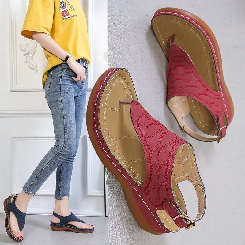 Women's wedge heel flip flop sandals with an adjustable buckle back strap in black.