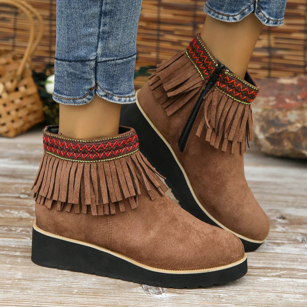 Women's suede ankle boot with wedge heel, side zipper, and tassel detail in dark brown.