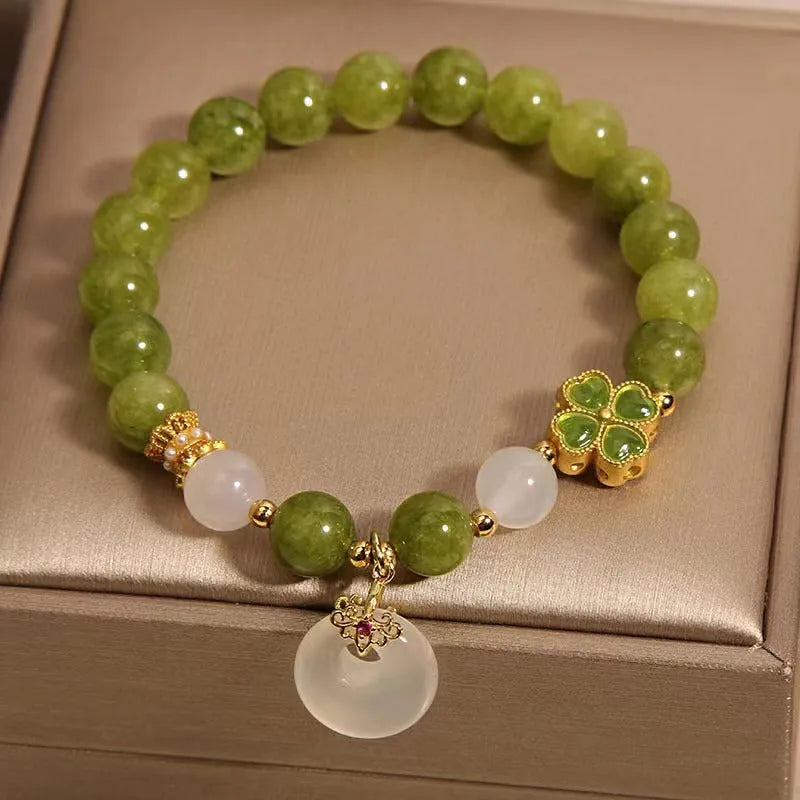 Green tourmaline four-leaf clover women's bracelet with safety buckle clasp on a white background.
