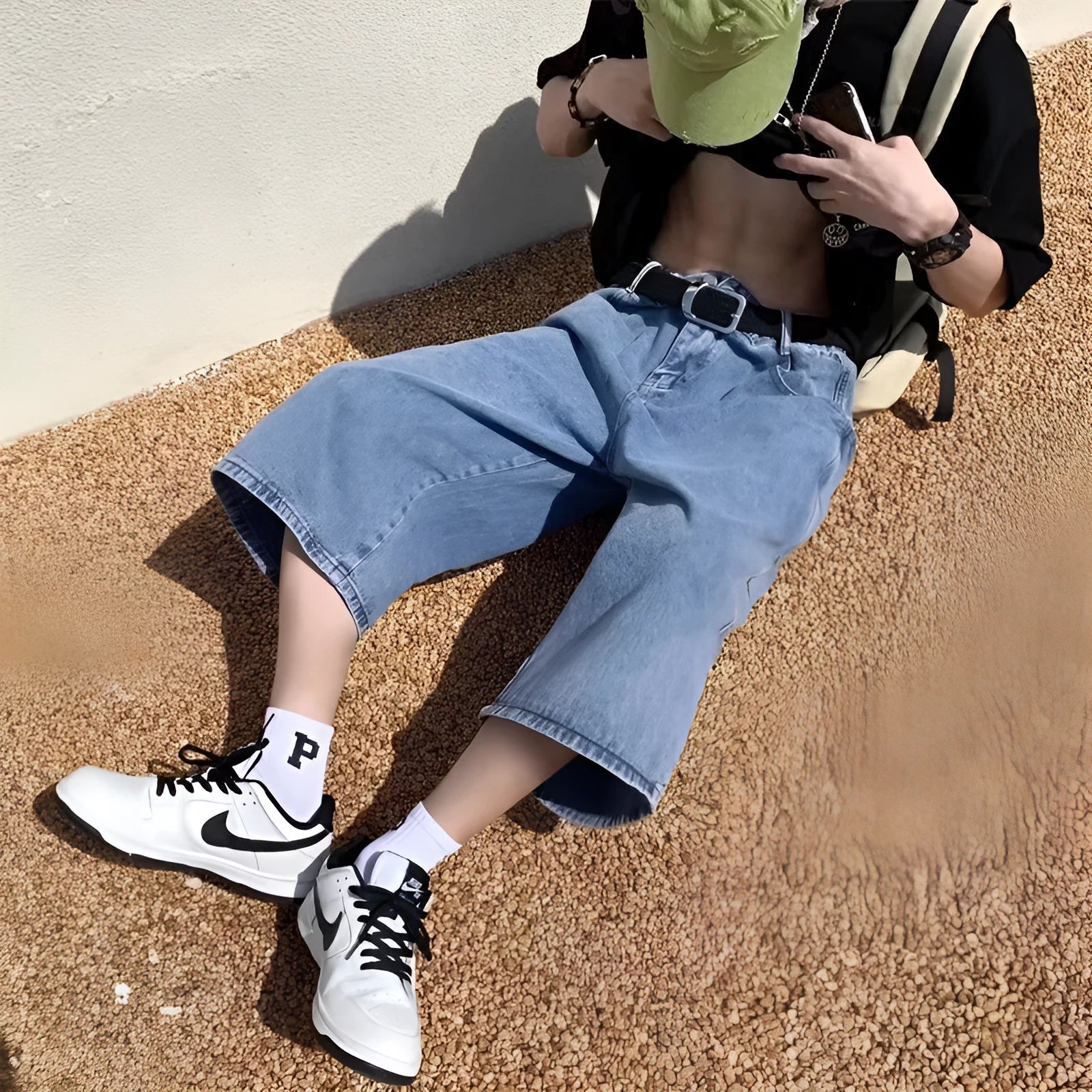 Man wearing blue washed denim shorts with a high waist, cropped leg, and straight cut.