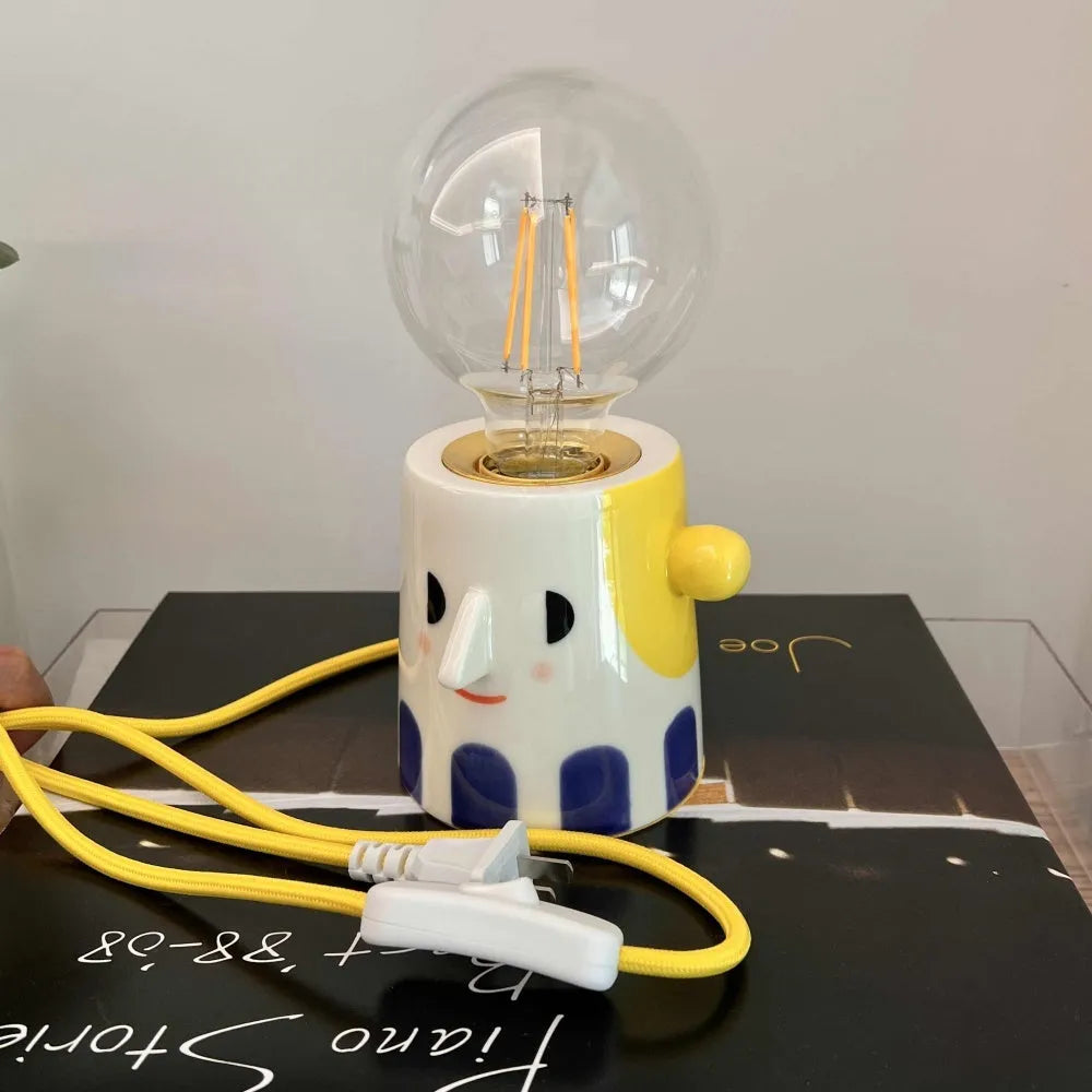 Handmade white ceramic bedside lamp with ball headlight design on wooden table