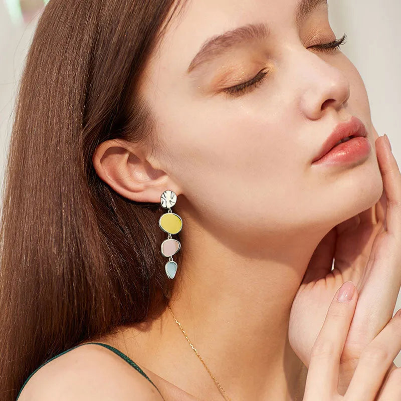 A pair of disc-shaped alloy earrings with a Morandi three-colour dripping oil finish on a sterling silver needle post.