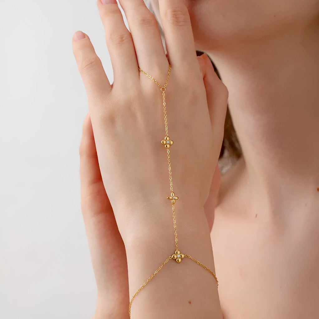Gold stainless steel women's bracelet with floral and eight-pointed star geometric design.