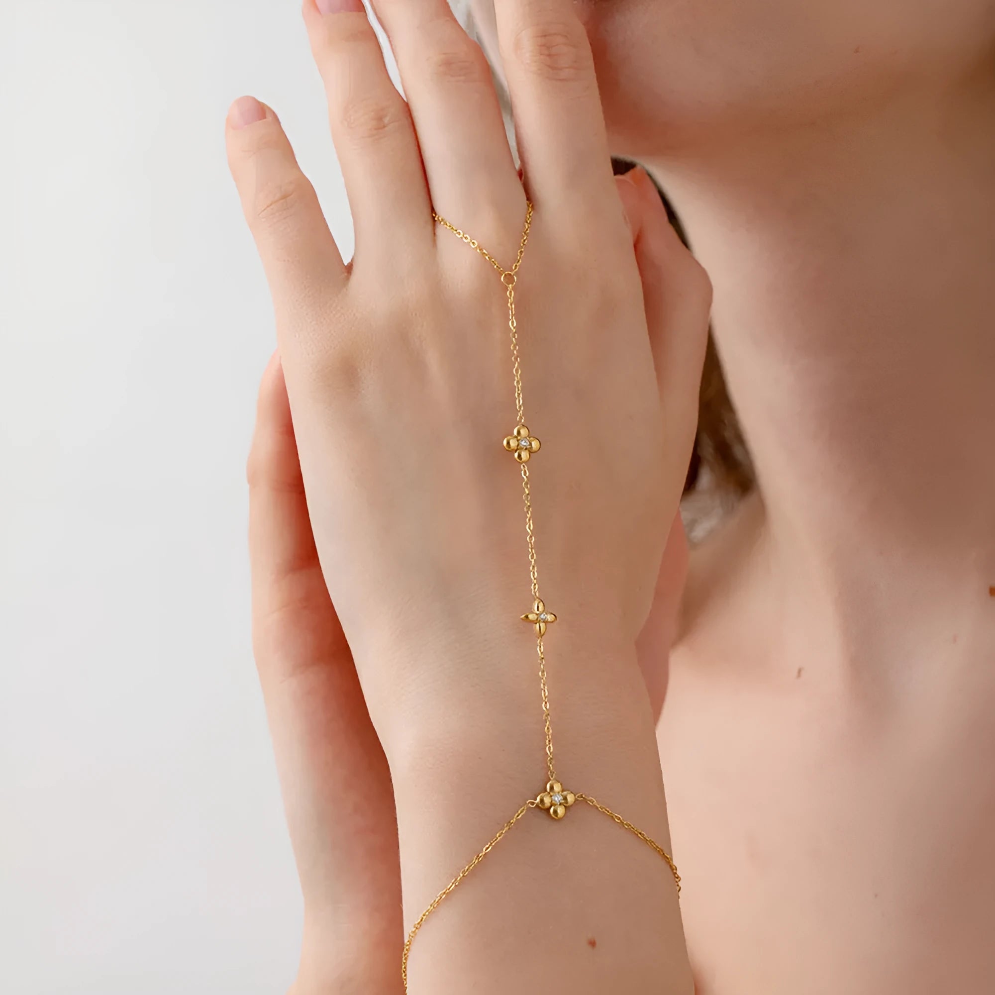 Gold stainless steel women's bracelet with floral and eight-pointed star geometric design.