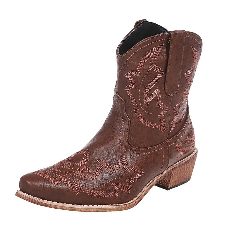 Women's blue embroidered cowboy boots with low wedge heel and pointed toe on a white background.