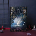 Blue A5 hardcover notebook with glowing night elves illustration, open to show colourful internal pages.