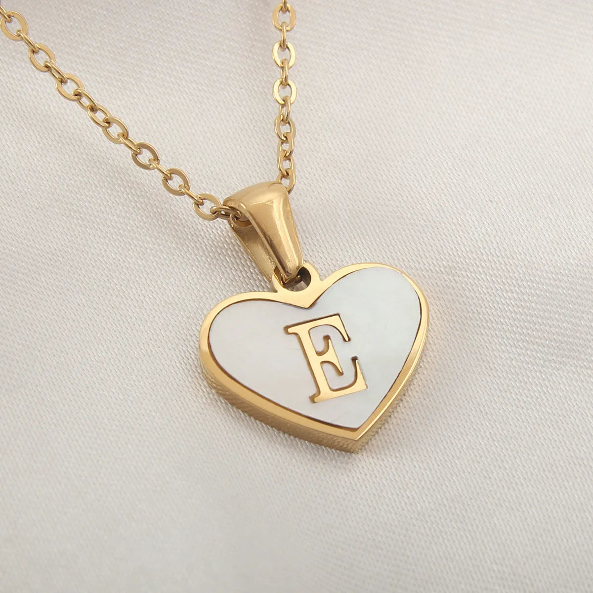 Gold plated heart-shaped necklace with white shell pendant on adjustable stainless steel chain