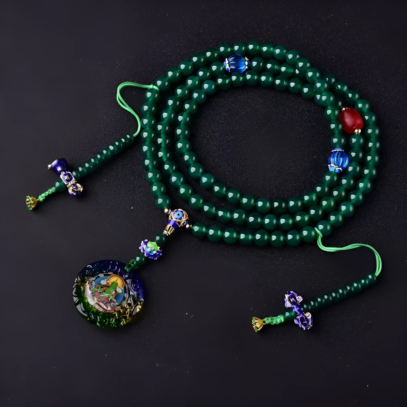 Natural green agate 108-bead bracelet with pendant in Thangka style on a wrist.