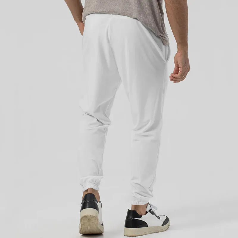 Men's grey loose-fit tapered track sweatpants with a straight leg on a neutral background.