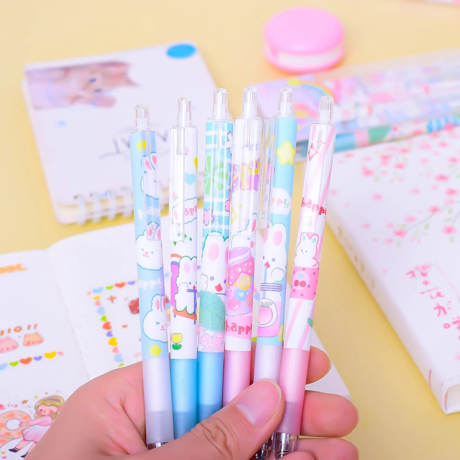 Set of six white plastic pens with black caps and a cartoon bunny character printed on the barrel.