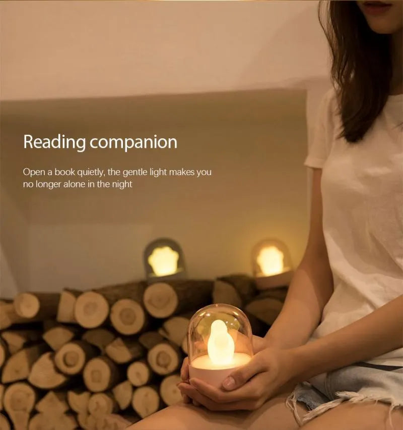 Grey cat paw shaped USB rechargeable night light and music box with soft glowing light.