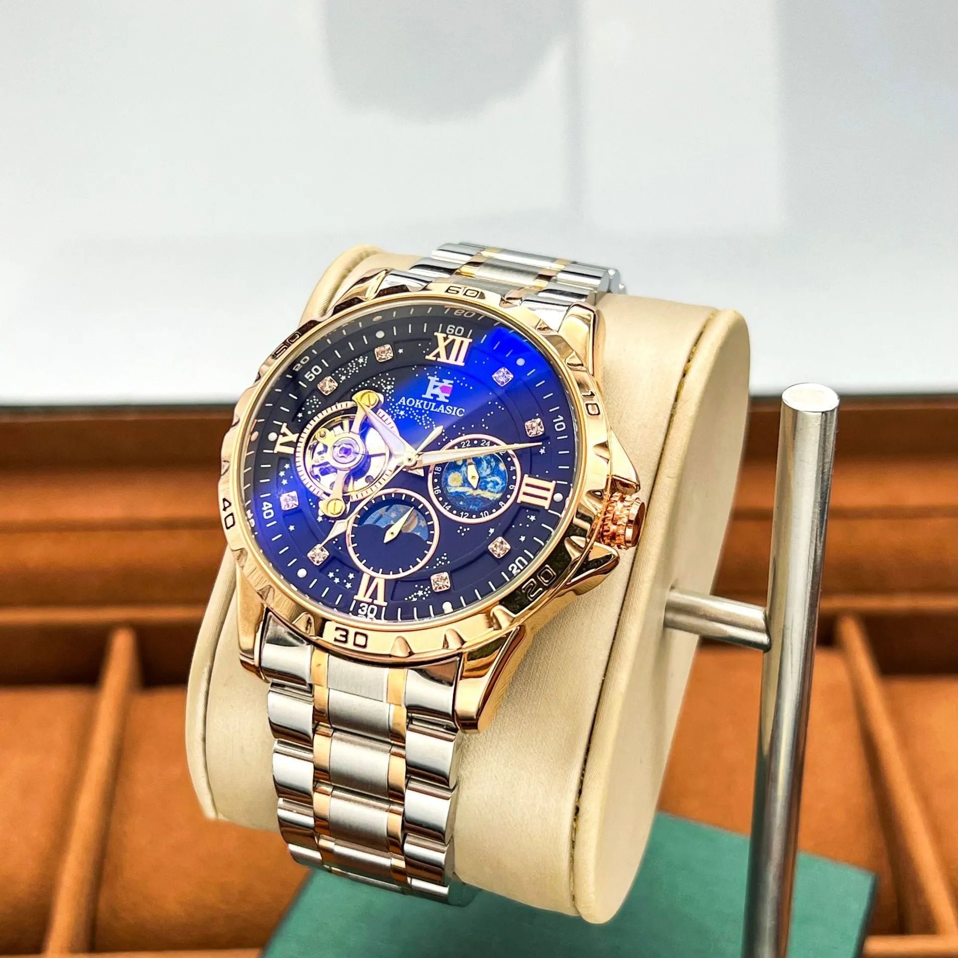 Men's rose gold automatic watch with large black dial on wrist.